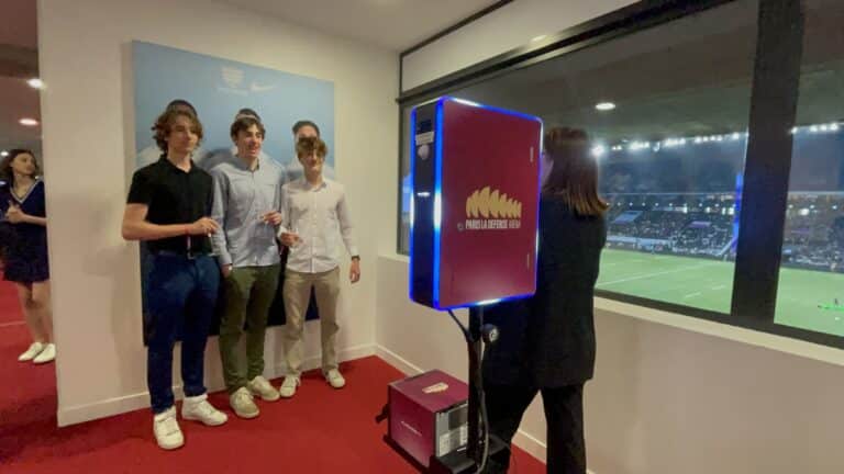 Borne photo Vegas de Shootnbox dans une loge de Paris La Défense Arena, invités qui posent devant la baie vitrée