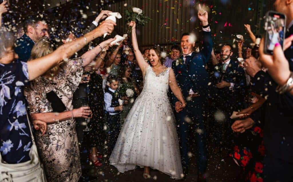 célébration des mariés arrivé diner après la mairie photo confettis robe blanche bouquet à la main