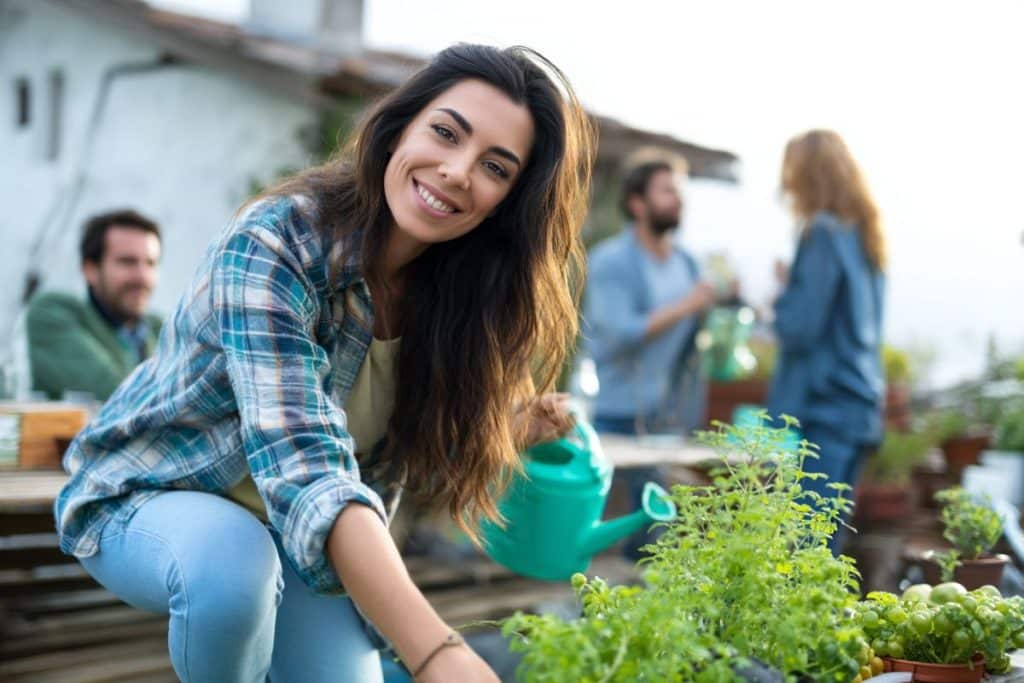 femme cultive plantes potager en entreprise toit terrasse avec ses collègues