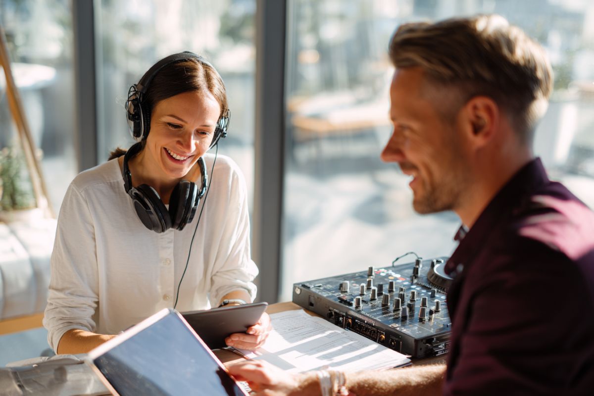 Couple de mariés en consultation avec DJ professionnel pour préparer la playlist et l'animation de mariage