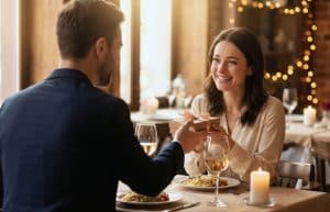 Couple heureux de 40 ans célébrant son anniversaire de mariage lors d'un dîner romantique avec échange de cadeau restaurant