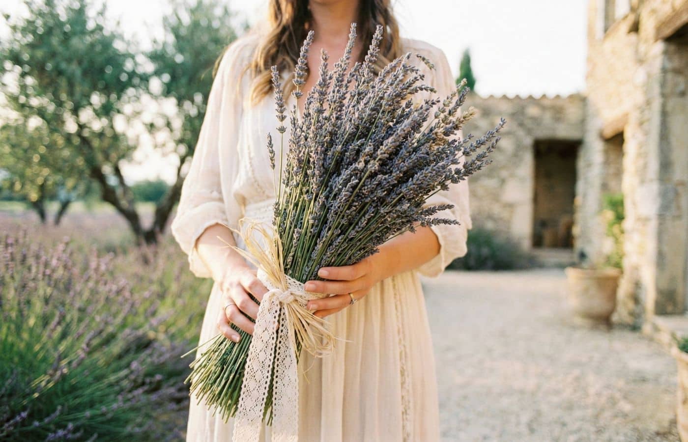 mariage provencal dans un mas en été mariée porte bouquet de lavande dans ses mains