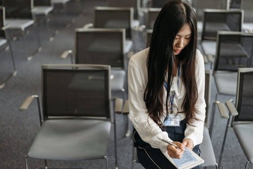 collaboratrice prenant des notes lors d'un séminaire d'entreprise à Paris