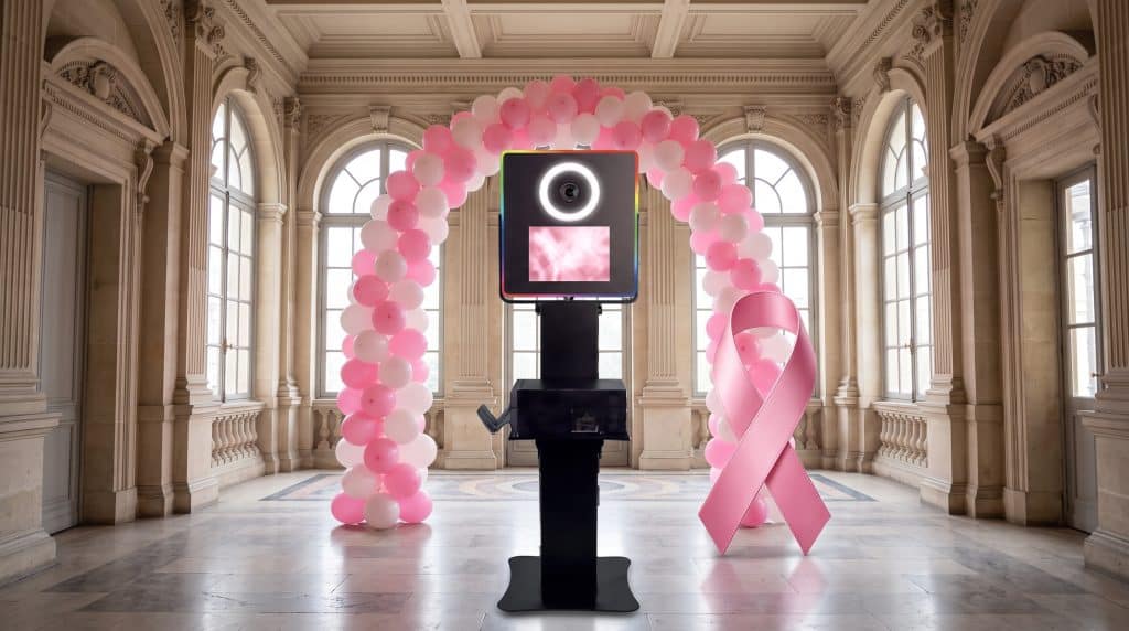 Photobooth Octobre rose : borne Vegas Shootnbox dans le hall d'une mairie, arche de ballons roses et ruban rose