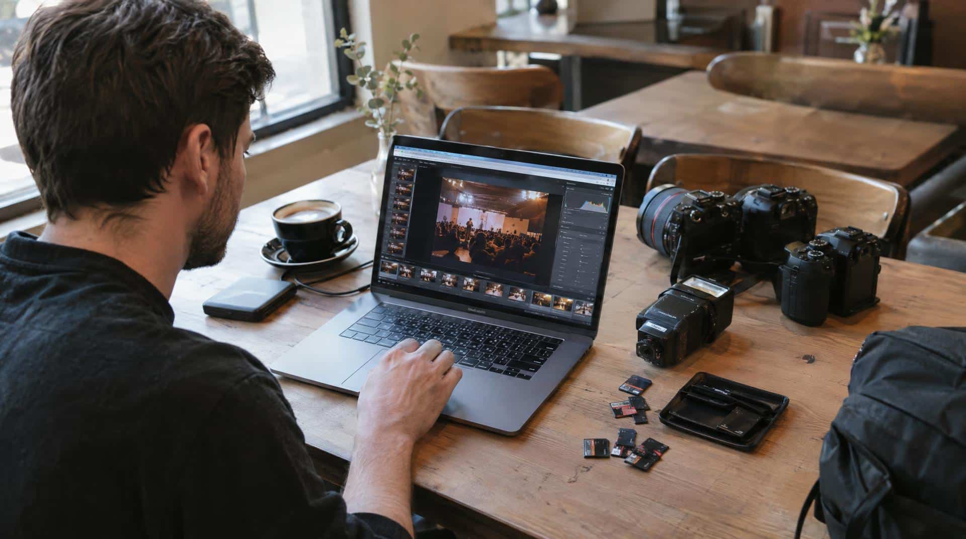 Photographe qui trie et retouche les photos d'un événement sur son ordinateur