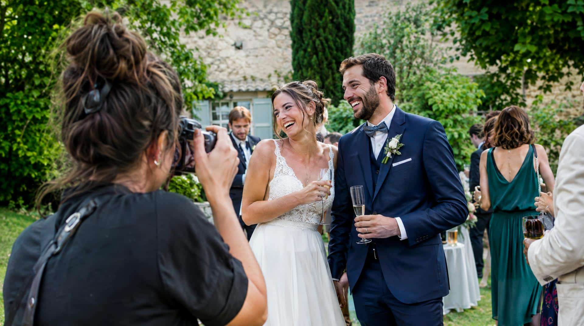 Reportage photo de mariage : le photographe saisit un éclat de rire des mariés pendant le vin d'honneur