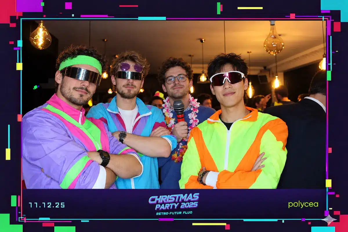 Tirage photobooth de la Christmas Party 2025 de Polycea, thème rétro-futur fluo : quatre collègues en vestes fluo et lunettes futuristes, daté du 11 décembre 2025