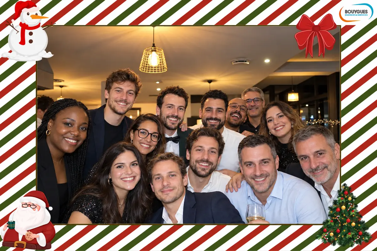 Photo de groupe au photobooth de Noël de Bouygues Énergies & Services, cadre à rayures rouges et vertes avec bonhomme de neige et Père Noël