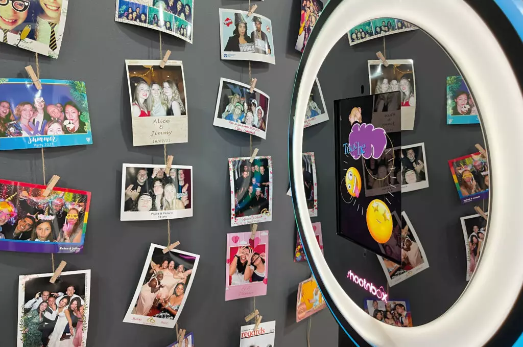 mur photos imprimées accroché sur des corde et pince à linge boise devant photobooth ringlight shootnbox écran tactile emoji