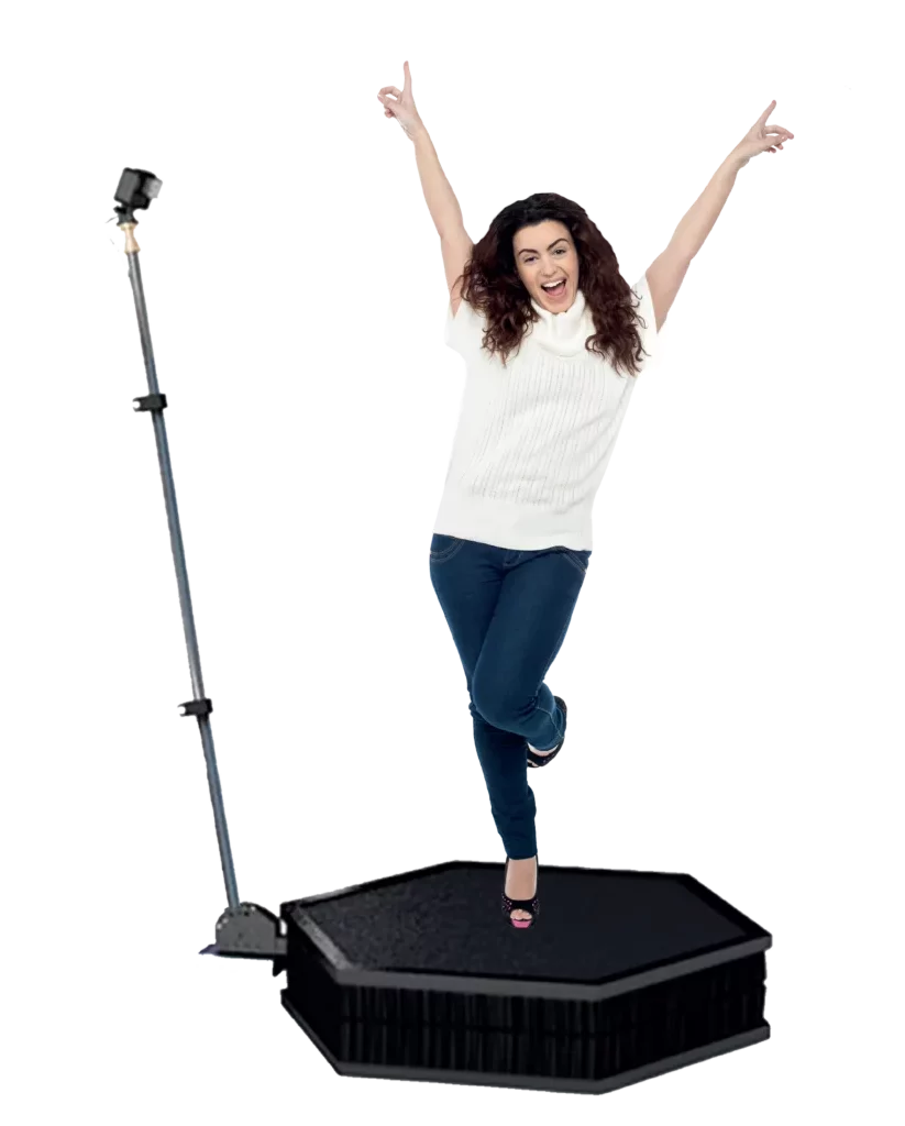 Une femme habillé d'un pull blanc à manche courte lève les bras et se tient sur un pied sur un vidéobooth 360 spinner avec gopro