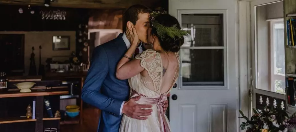 couple qui s'embrasse mariage costume bleu robe blanche vintage maisonnette bois cuisine