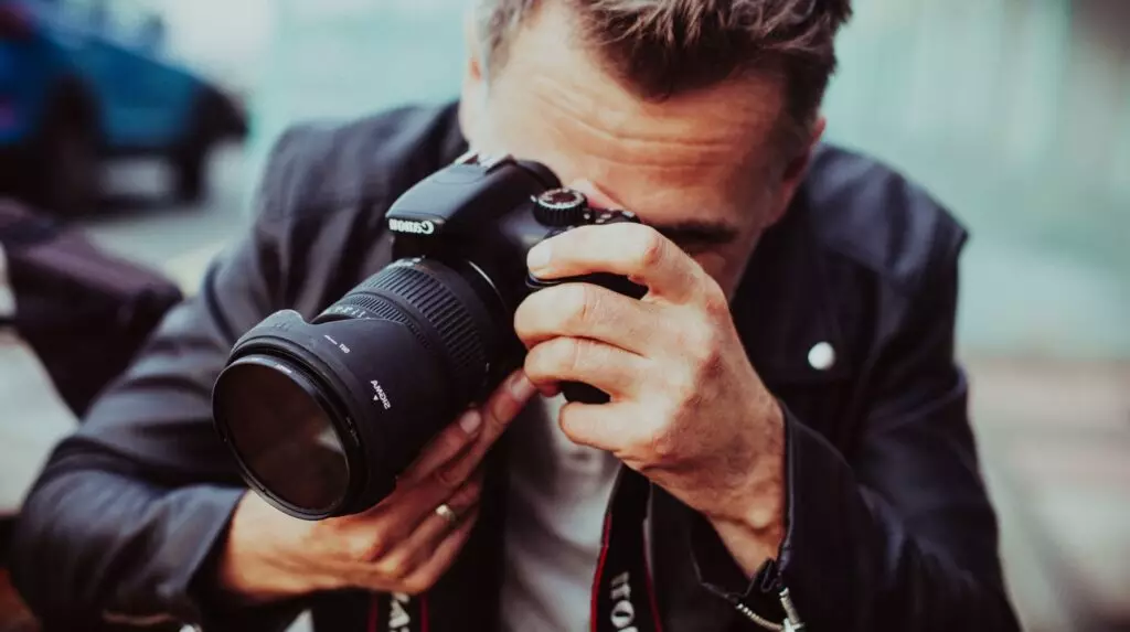 photographe professionnel blouson cuir appareil canon objectif oeil viseur