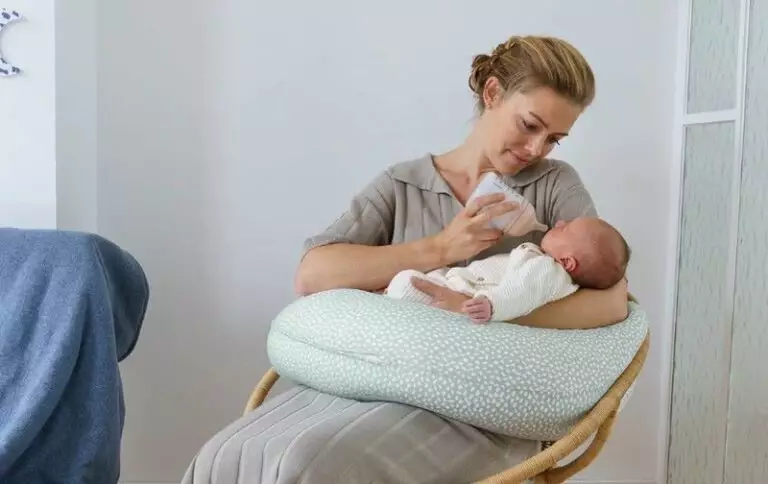 maman femme coussin allaiter bébé biberon assis sur une chaise