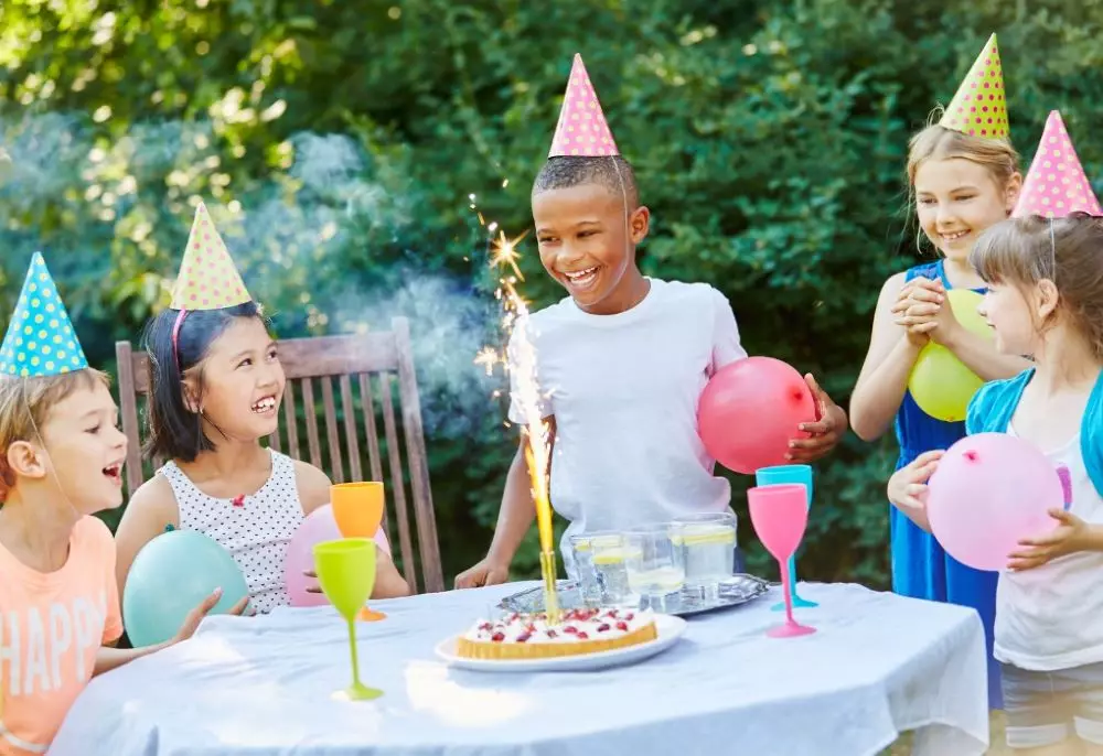 anniversaire 10 ans garçon fille bougie feu de bengale enfant gateau chocolat table jardin chapeau pointu fête