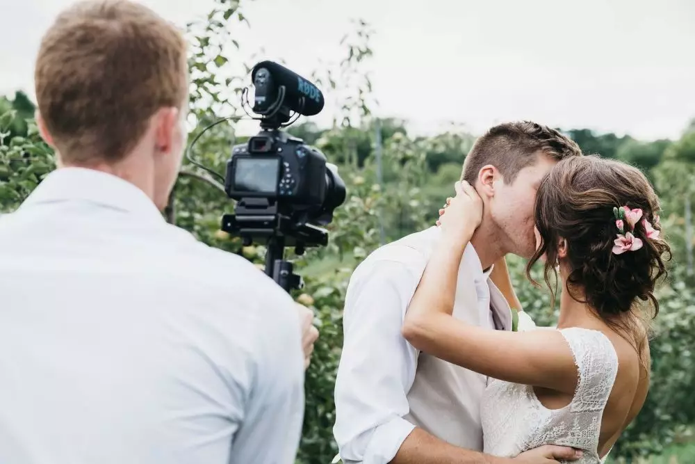 photographe de mariage vidéaste micro rode bonnette couple mariés embrassade bisou champs exterieur