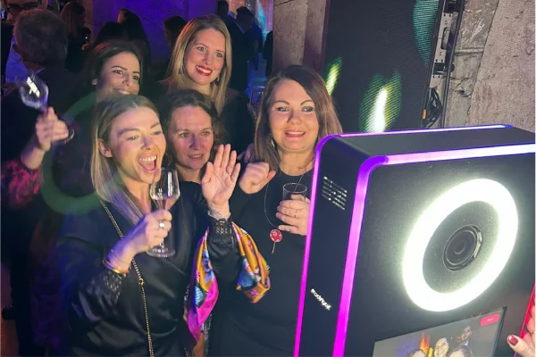 prise de photo de cinq femmes habillées chic lors d'une soirée devant un appareil photobooth shootnbox